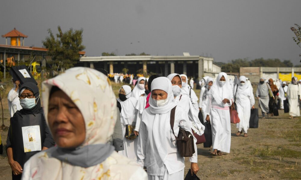 people in white hijab standing on brown field during daytime