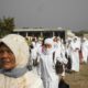 people in white hijab standing on brown field during daytime