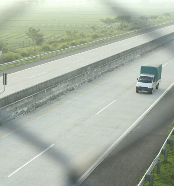 a group of cars driving on a highway