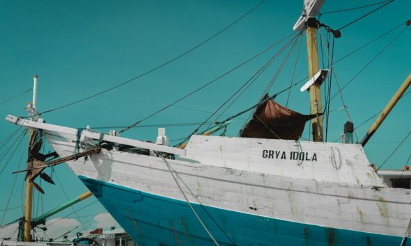 white and blue shipping boat floating near dock