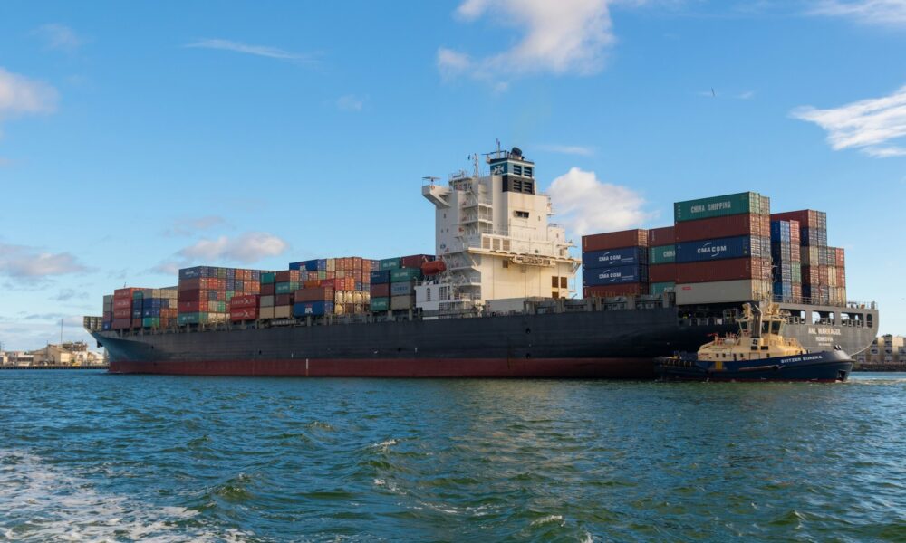 black cargo ship on sea under blue sky during daytime