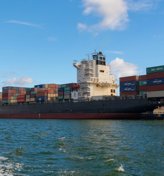 black cargo ship on sea under blue sky during daytime