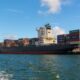 black cargo ship on sea under blue sky during daytime