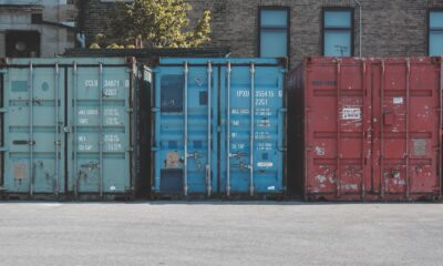 blue steel container van on gray asphalt road during daytime