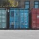 blue steel container van on gray asphalt road during daytime