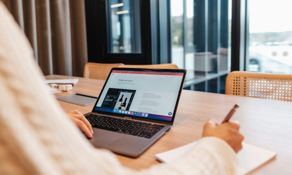 a person sitting at a table with a laptop