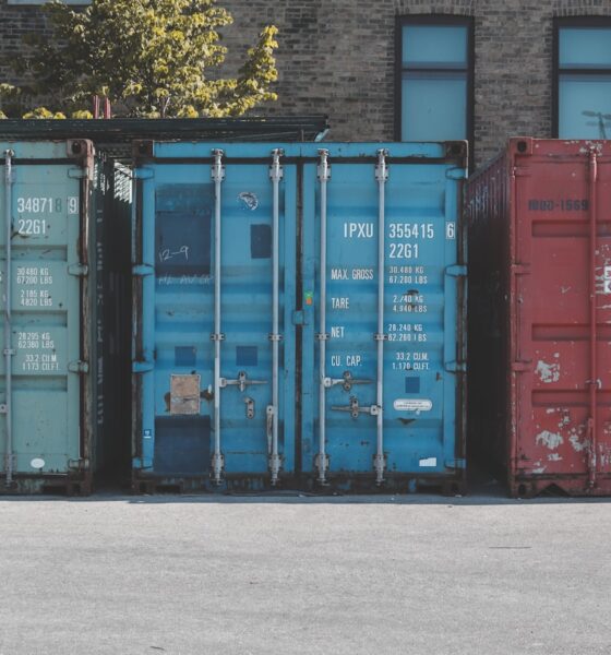 blue steel container van on gray asphalt road during daytime