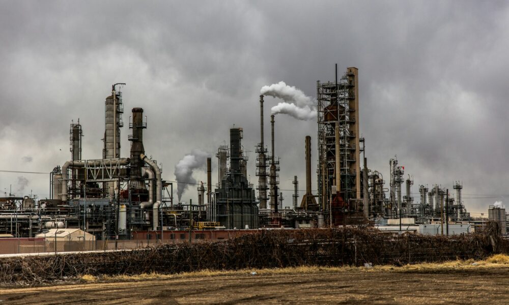 factories with smoke under cloudy sky