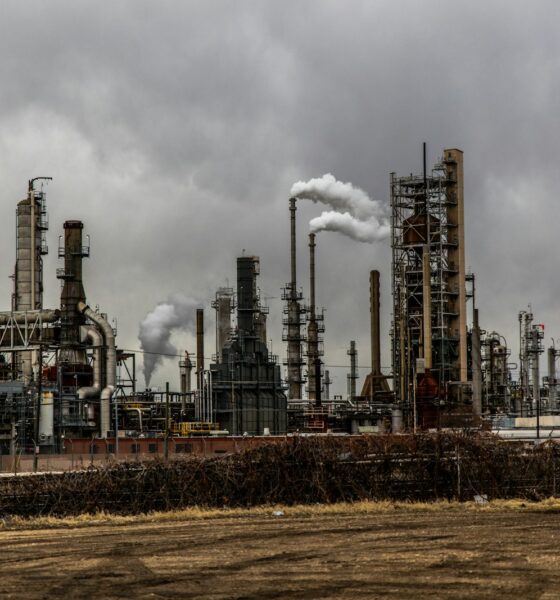 factories with smoke under cloudy sky